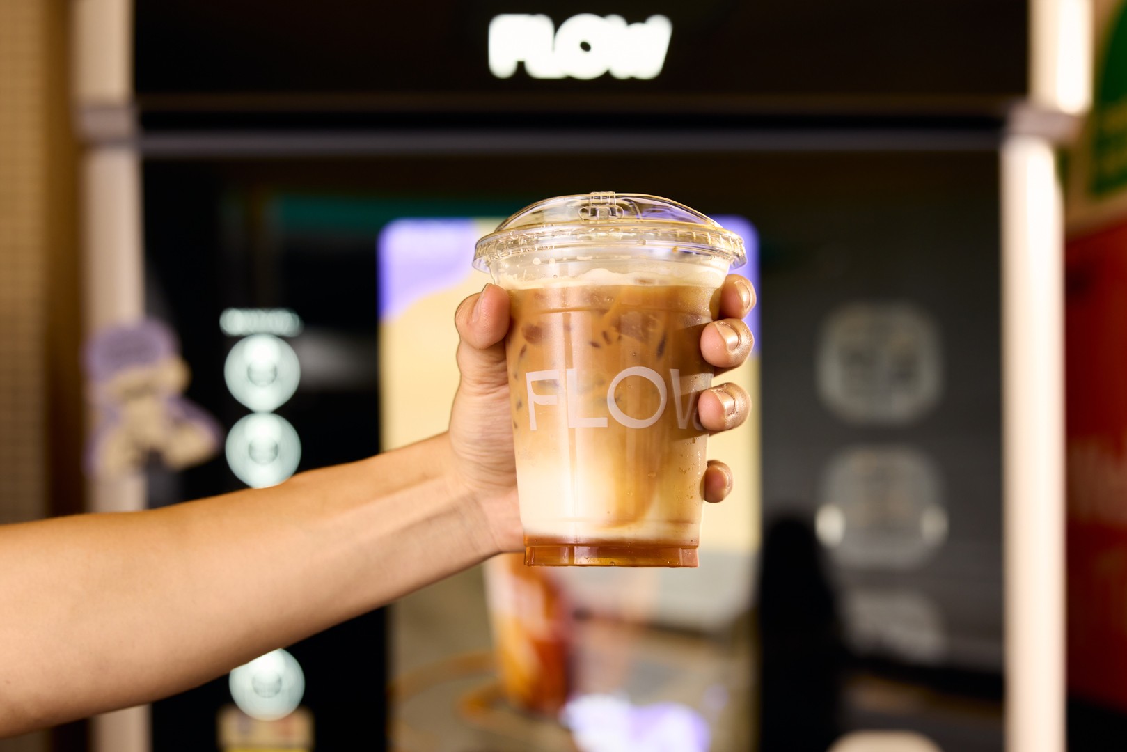 A freshly dispensed iced latte from a Flow Coffee machine — made with real milk, not powder.